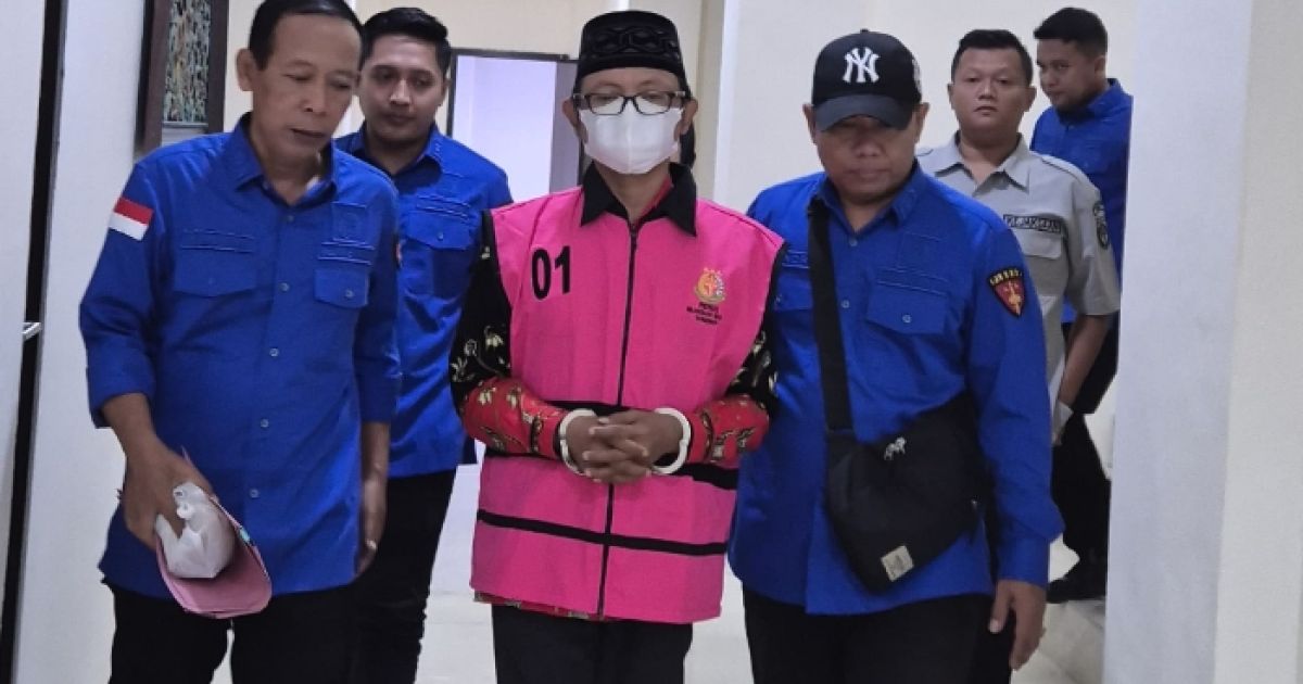 Kades Imrah (tengah) menggunakan rompi merah jambu khas kejaksaan, tersangka dugaan korupsi. (Foto : liputan12).