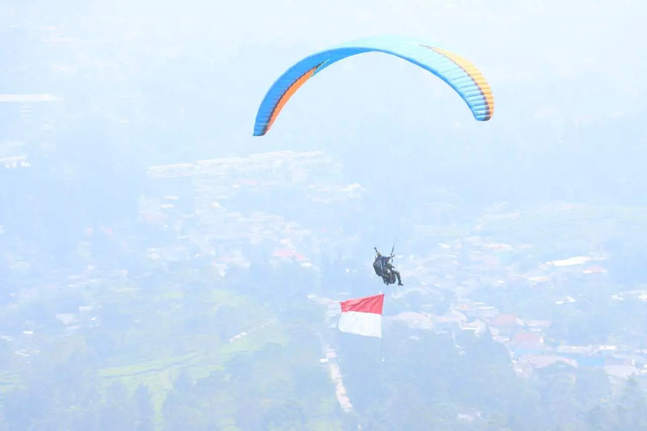 Meriahkan HUT ke-76 Bhayangkara, Polres Bogor Kibarkan Bendera Merah Putih Lewat Penerbangan Paralayang