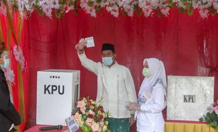 Kompak Berbaju Putih, Ahmad Fauzi Didampingi Sang Istri Nyoblos di TPS 03 Desa Torbang