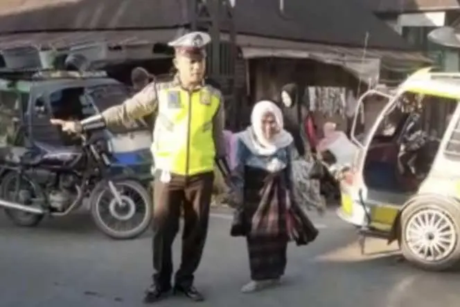 Personil Sat Lantas Polres Madina Membantu Seorang Nenek Jompo Yang Hendak Menyeberang Jalan